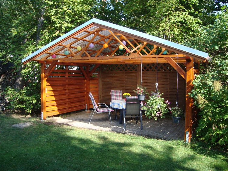 überdachter Grillplatz mit Gartenmöbeln und Grill